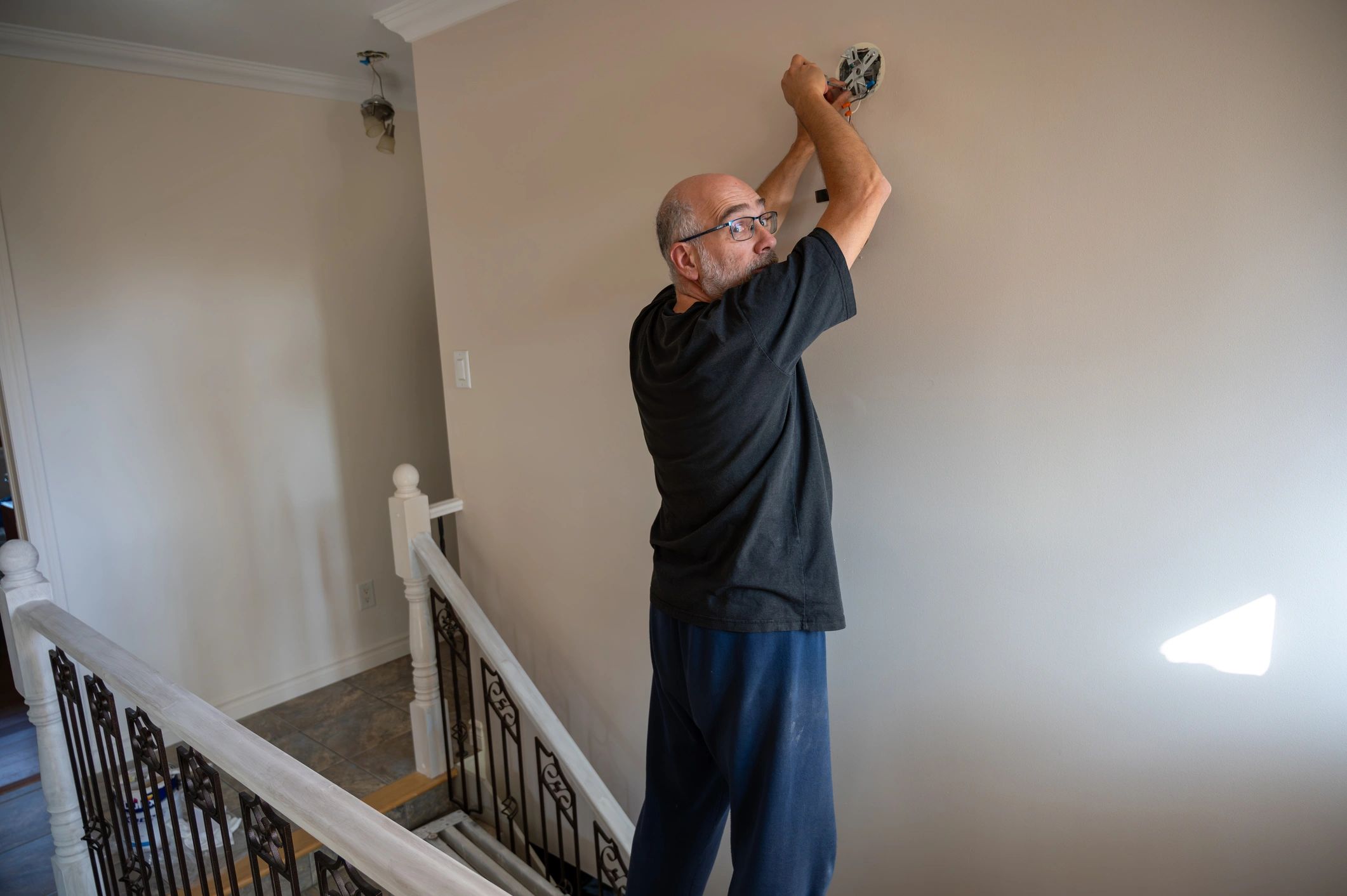 Technician installing a wall-mounted security device